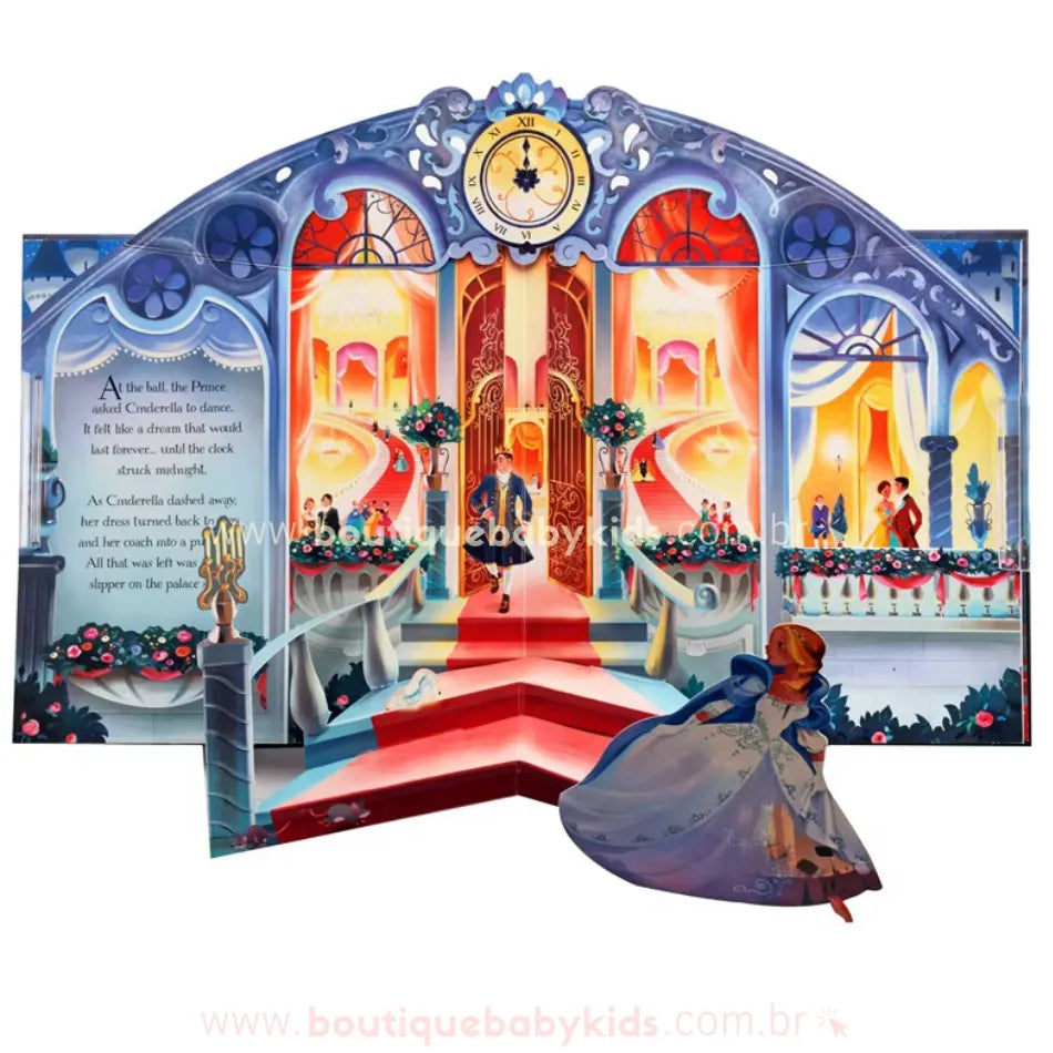 Página interna do livro pop-up da Cinderela, apresentando uma cena encantada do baile real. O relógio no topo marca quase meia-noite, enquanto Cinderela corre para sair, deixando seu sapatinho de cristal para trás. A ilustração tem um efeito tridimensional detalhado.