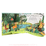 Página do livro Pop-Up Nature representando um cenário florestal cheio de vida, com cervos, coelhos, esquilos e pássaros entre árvores e um lago. As camadas em pop-up adicionam profundidade à cena.