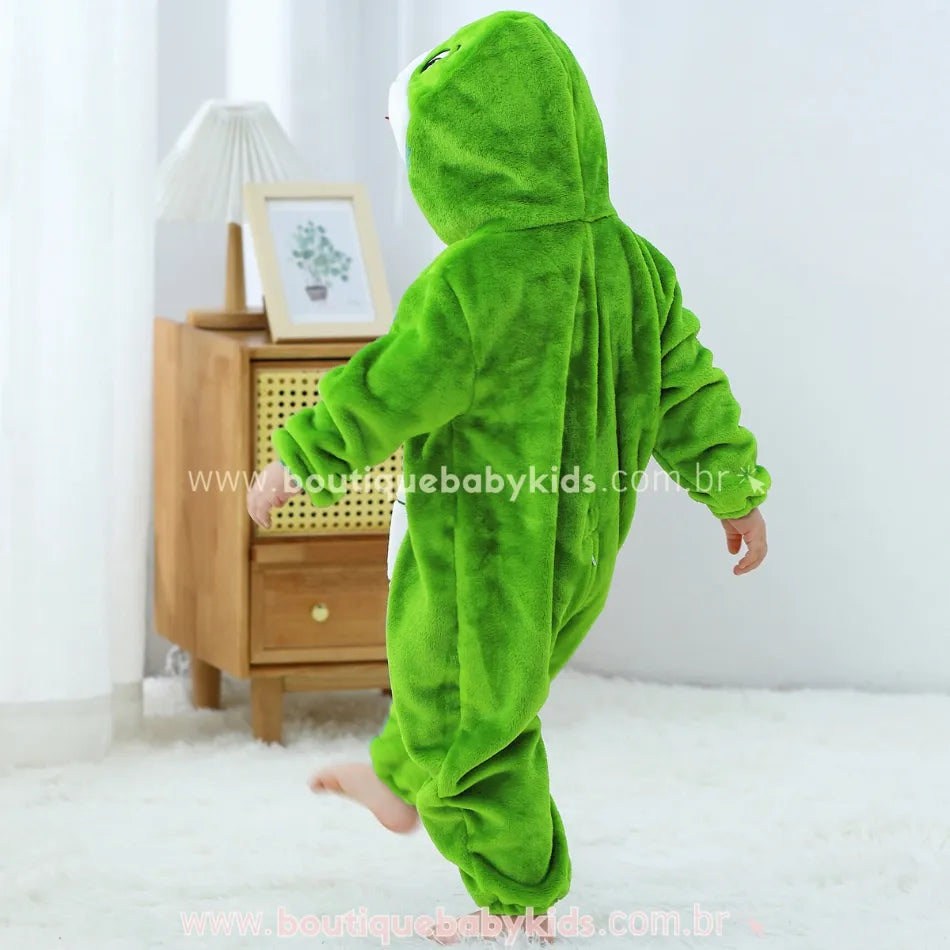 Criança de costas andando, com capuz da fantasia de serpente cobrindo a cabeça e detalhe de língua vermelha no capuz. 