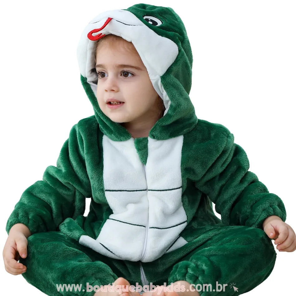 Close frontal da criança sentada com o macacão de serpente, evidenciando a barriguinha branca, o capuz com olhos bordados e a linguinha vermelha. #verde-escuro