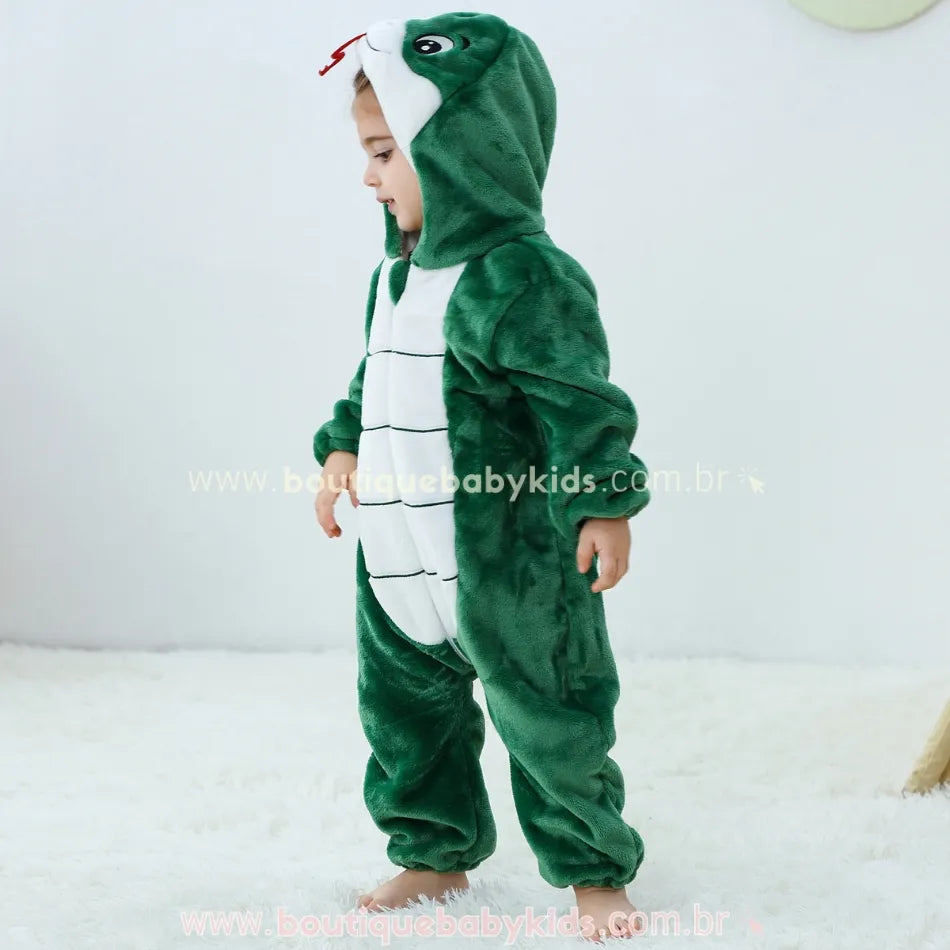 Vista lateral do macacão com a criança andando, destacando o caimento da peça e o capuz detalhado com o rosto da serpente. 