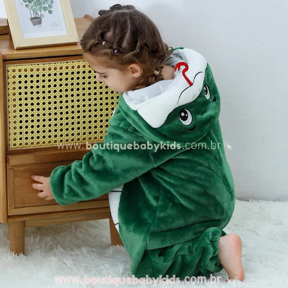 Criança agachada de lado, com foco no capuz da fantasia mostrando a expressão da serpente com olhos grandes e a língua vermelha tridimensional. 