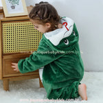 Criança agachada de lado, com foco no capuz da fantasia mostrando a expressão da serpente com olhos grandes e a língua vermelha tridimensional. 