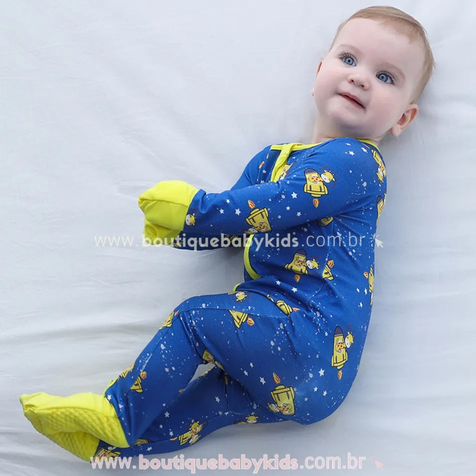 Bebê usando o macacão de bambu com estampa de girafinhas astronautas, punhos dobráveis como luvinhas.