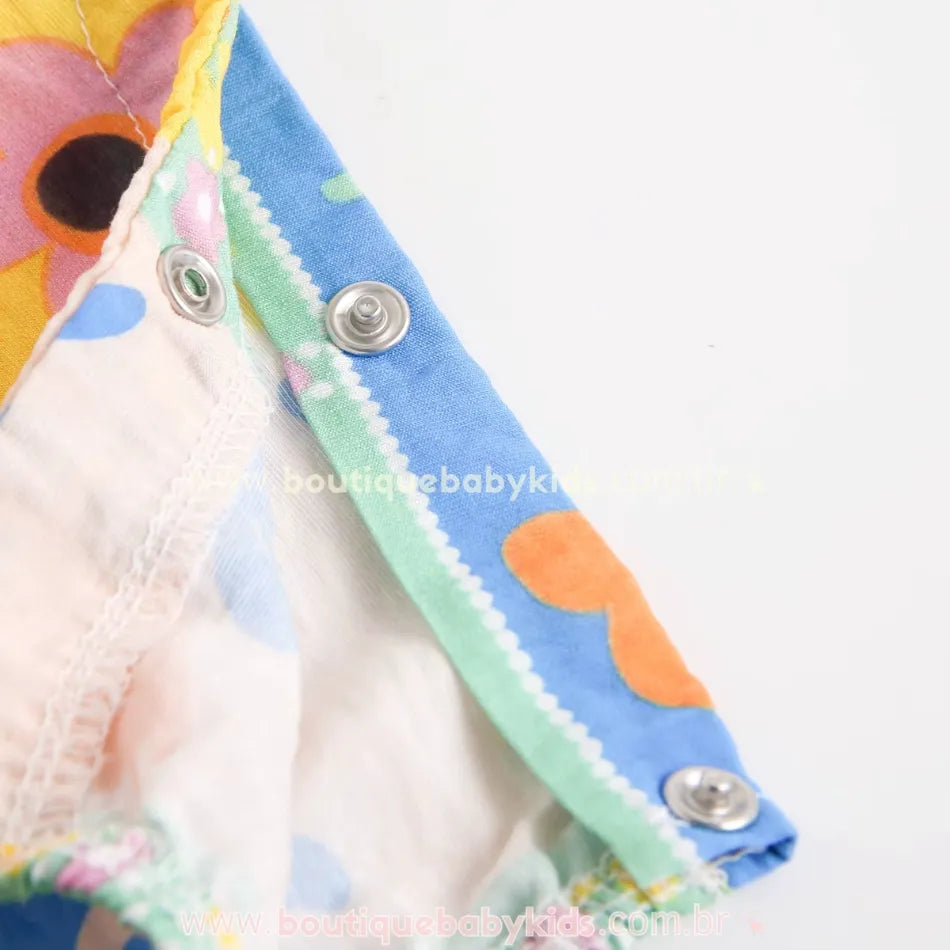 Macacão bebê em viscose com estampa floral multicolorida e fechos de pressão entrepernas.