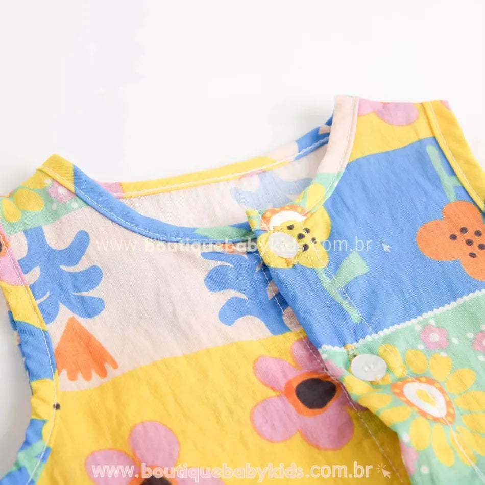 Macacão infantil em tecido respirável com botões frontais e estampa alegre de flores.