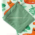 Punho dobrável do macacão bebê com tecido canelado verde e estampa divertida de oncinha.