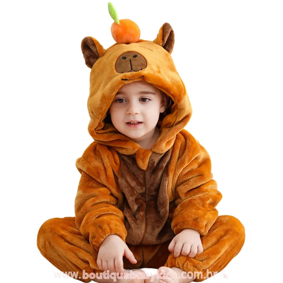 Close da criança sentada com capuz levantado, evidenciando os detalhes bordados do rostinho da capivara.