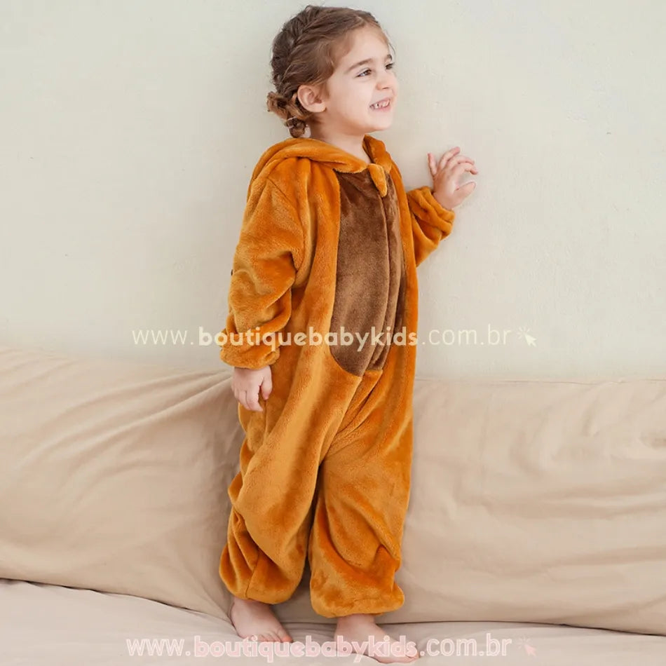 Criança em pé lateralmente, sorrindo e vestindo o macacão de capivara com detalhe do barriguinha marrom em destaque.