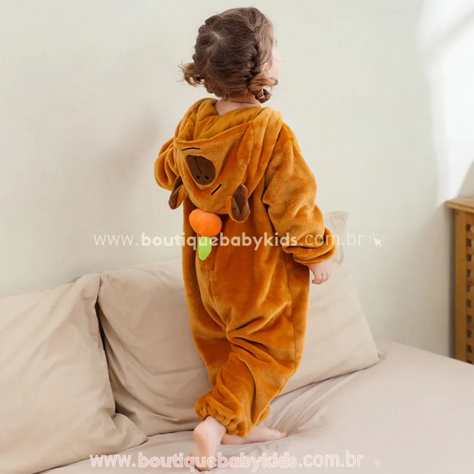 Vista traseira do macacão com a criança de costas, destacando o capuz com o rostinho da capivara e um detalhe de laranjinha tridimensional.