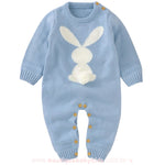 Macacão bebê tricot coelhinho na cor azul claro, com estampa de coelho branco e rabinho pompom. Possui mangas longas e botões de madeira para facilitar a troca. 