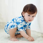 Criança agachada com macaquinho de tubarão em fibra de bambu, em fundo claro