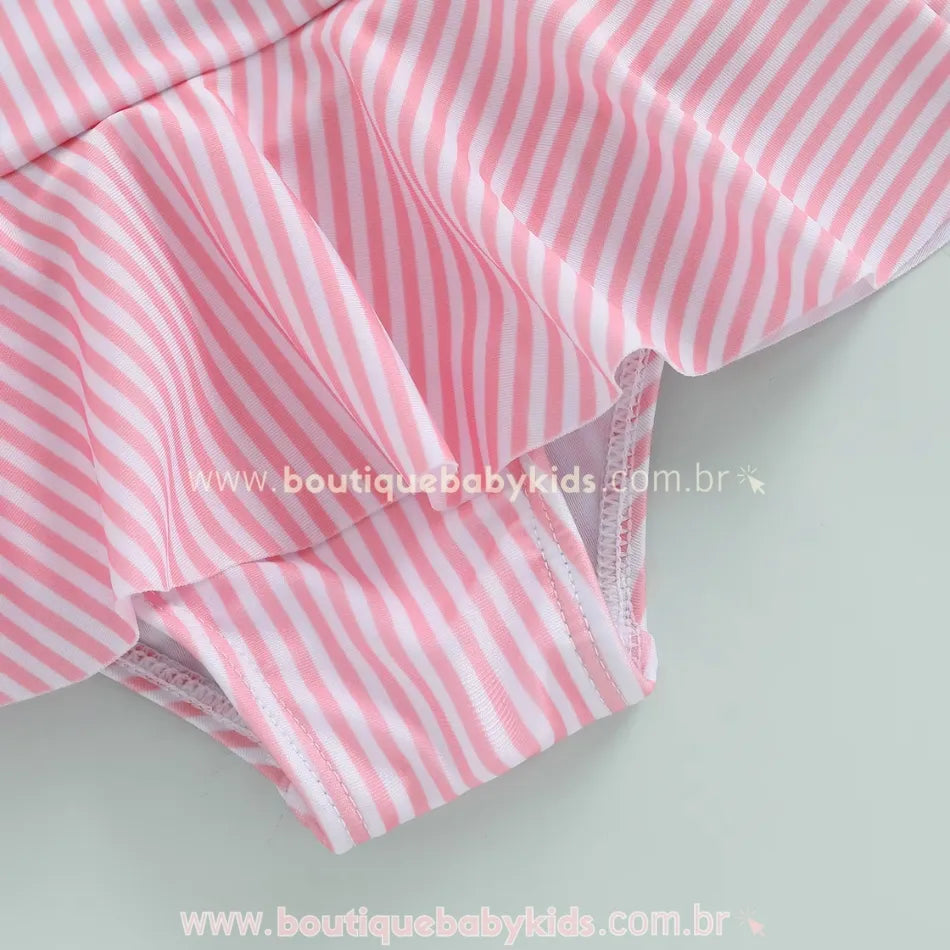 Detalhe da costura reforçada e acabamento do maiô bebê listrado rosa com babado