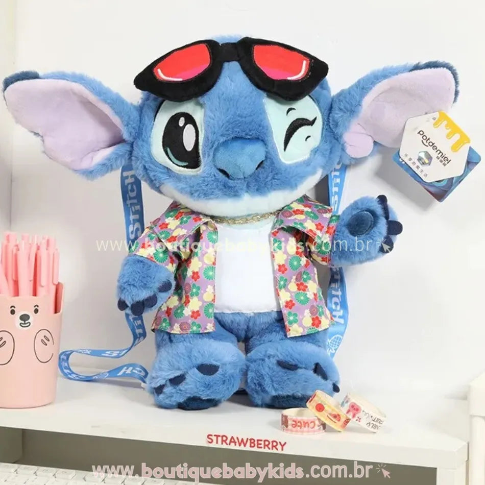 Pelúcia Stitch 30 cm estilo havaiano com camisa floral, colar dourado e óculos vermelhos, exposta em ambiente decorado.