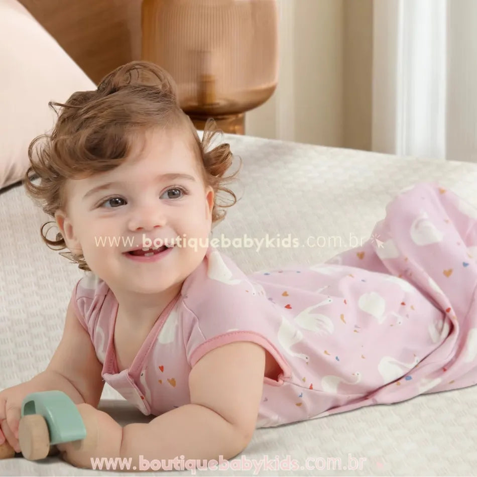 Vídeo demonstrativo do Saco de Dormir Bebê Estampa Cisnes Rosa, destacando o design sem mangas, o zíper duplo para facilitar a troca de fraldas e o tecido 100% algodão respirável. Mostra um bebê confortável e seguro durante o sono e momentos de brincadeira, evidenciando a maciez do material e a praticidade do fechamento com proteção no pescoço. Ideal para noites tranquilas e aconchegantes.