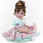 Vídeo da Boneca Bebê Reborn Maria 55 cm em diferentes ângulos, com cabelo cacheado que pode ser preso ou solto, vestida com roupa colorida e acessórios como chupeta, mamadeira e colar de coração.