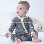 Bebê sentado usando macacão cinza com estampa de caminhõezinhos, feito em fibra de bambu, com punhos creme e zíper frontal – Boutique Baby Kids.