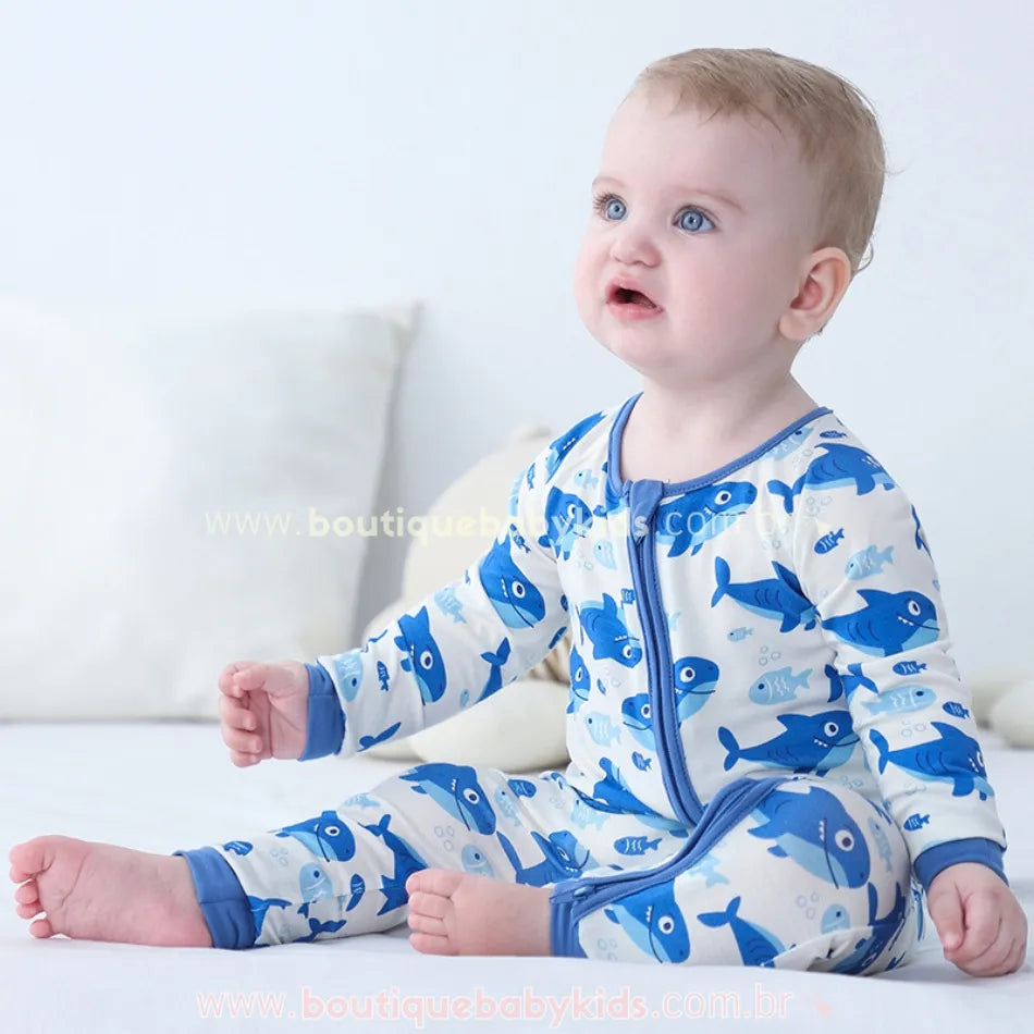 Vídeo do bebê usando o Macacão Bebê Tubarãozinho Azul feito em fibra de bambu, com estampa de tubarões e peixinhos sobre fundo claro – Boutique Baby Kids.
