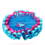 Saia aberta em formato circular, destacando a estrutura volumosa do tule e as fitas de cetim onduladas na barra.