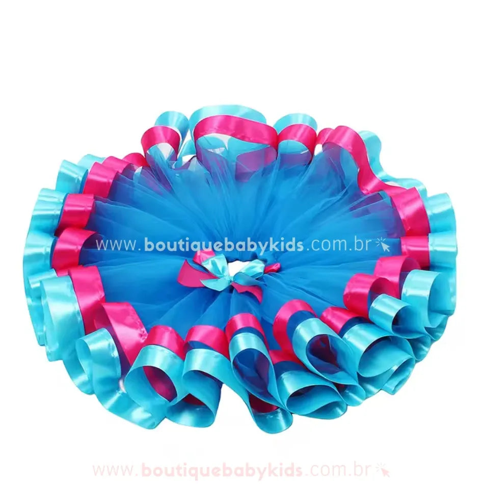 Saia aberta em formato circular, destacando a estrutura volumosa do tule e as fitas de cetim onduladas na barra.