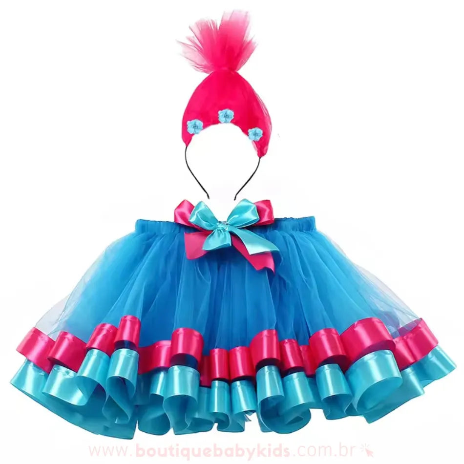 Conjunto completo da fantasia infantil Poppy Trolls, composto por saia de tule azul com detalhes rosa e azul e tiara temática com cabelo rosa estilizado e pequenas flores decorativas.