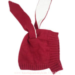 Touca de tricot vermelha com orelhinhas de coelho, exibindo detalhes do tecido e da costura.