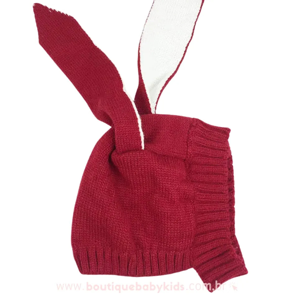 Touca de tricot vermelha com orelhinhas de coelho, exibindo detalhes do tecido e da costura.