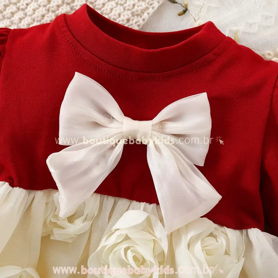 Laço branco delicado em destaque na parte superior vermelha do vestido bebê.