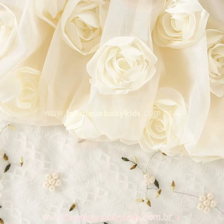 Detalhe das rosas brancas em relevo aplicadas na saia do vestido infantil.