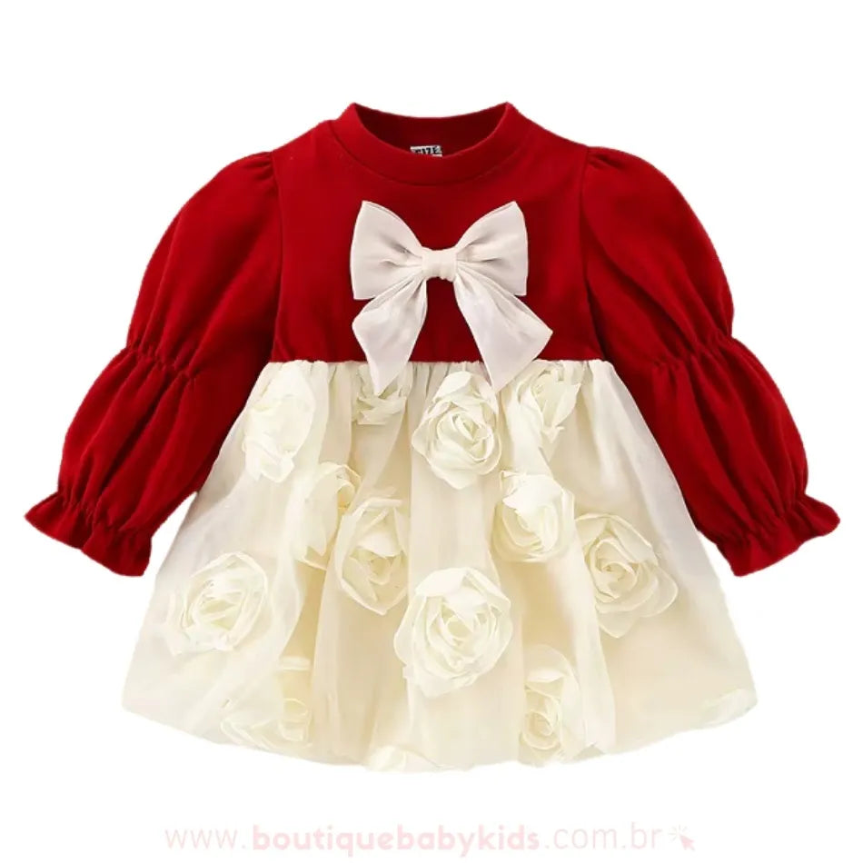 Vestido bebê com corpo vermelho, laço branco e saia decorada com rosas em relevo sobre fundo branco.