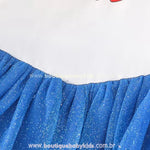 Close-up da costura entre o corpete branco e a saia de tule azul brilhante, destacando a textura delicada do tecido e os brilhos sutis do tule.