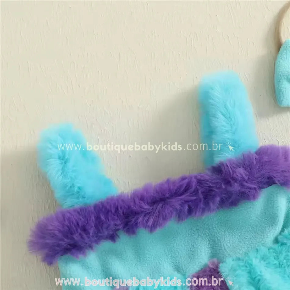 Destaque das alcinhas peluciadas do vestido, em azul claro, com aplicação de detalhes que remetem aos chifrinhos do personagem Sulley.