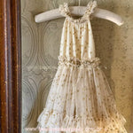 Vestido Infantil Brilho das Estrelas pendurado em cabide acolchoado. Modelo frente única com gola franzida, cintura marcada e saia longa em camadas de tule com estrelas.