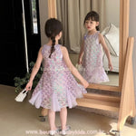 Criança em frente ao espelho mostrando a parte de trás do vestido de festa tema Sereia, com saia de tule e acabamento delicado.