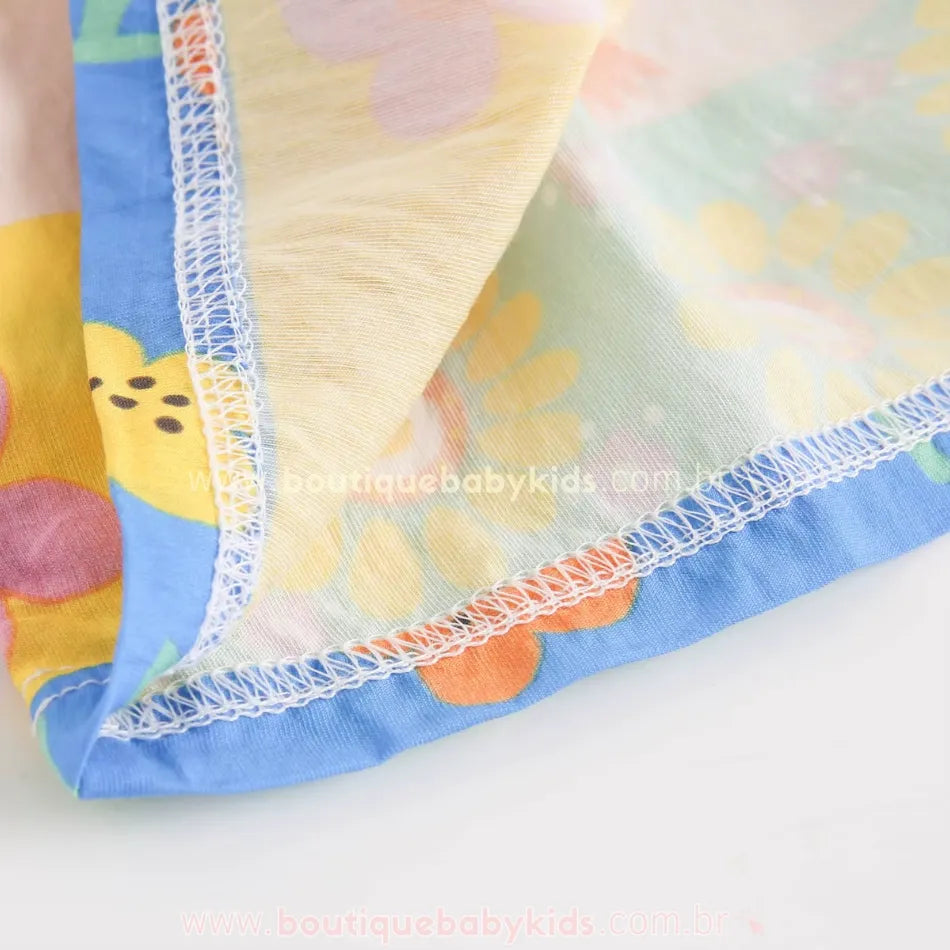 Detalhe interno da costura do vestido infantil com estampa floral colorida em tecido de viscose leve.