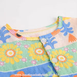 Vista superior do decote redondo com botão, destacando o acabamento e estampa floral. - Boutique Baby Kids