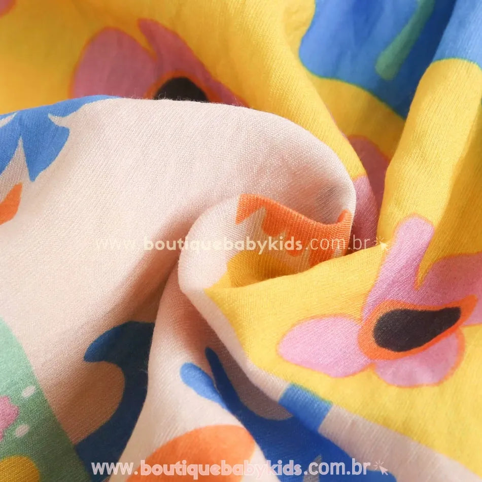 Textura do tecido do vestido infantil com flores coloridas, mostrando leveza e maciez. - Boutique Baby Kids