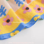 Barra do vestido infantil com acabamento delicado e estampa de florzinhas em tons vibrantes.