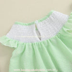 Detalhe das costas do vestido infantil com botão e decote em lastex branco.