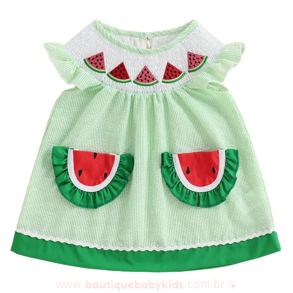 Vista frontal do vestido infantil temático com bolsos em forma de melancia e bordado superior.