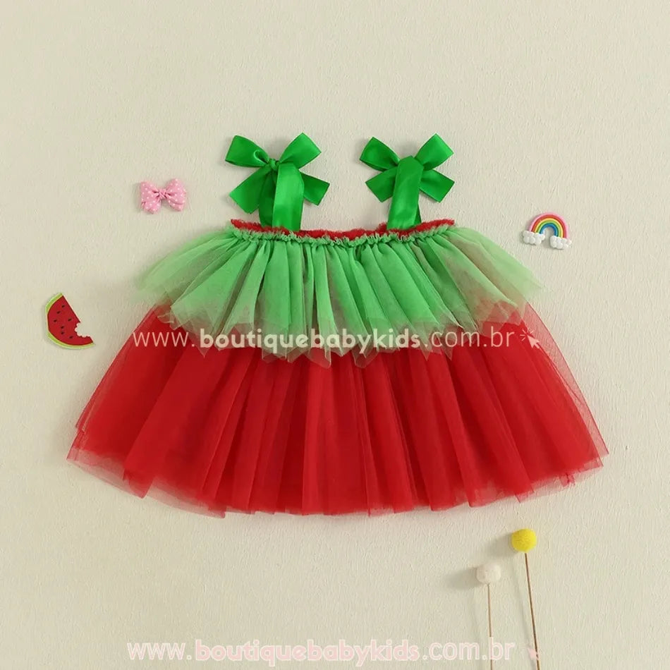Parte de trás do vestido infantil melancia com tule verde e vermelho e alças de laço em fundo decorado