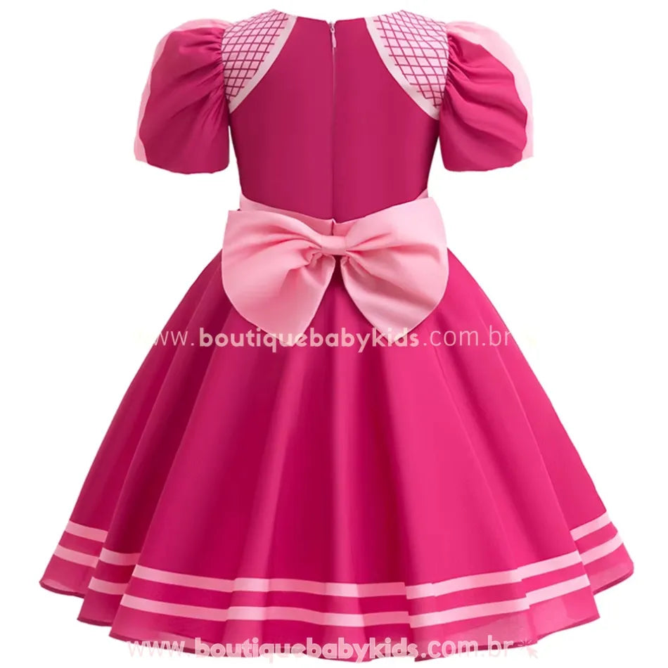 Vista traseira do vestido infantil temático Skye Patrulha Canina, destacando o grande laço rosa e o fechamento em zíper.
