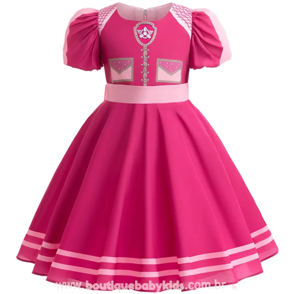 Vestido infantil rosa inspirado na personagem Skye da Patrulha Canina, com saia rodada e detalhes estampados na parte frontal.