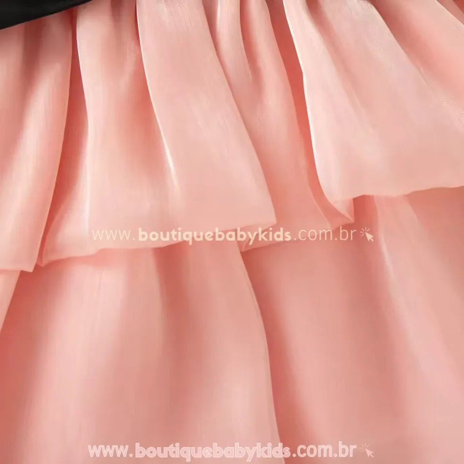 Detalhe da saia rosa em camadas de tule leve e transparente.