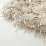 Detalhe em close da saia do Vestido Infantil Tweed Belle Plume, destacando as franjas texturizadas na cor off-white e o bordado sofisticado com paetês dourados.