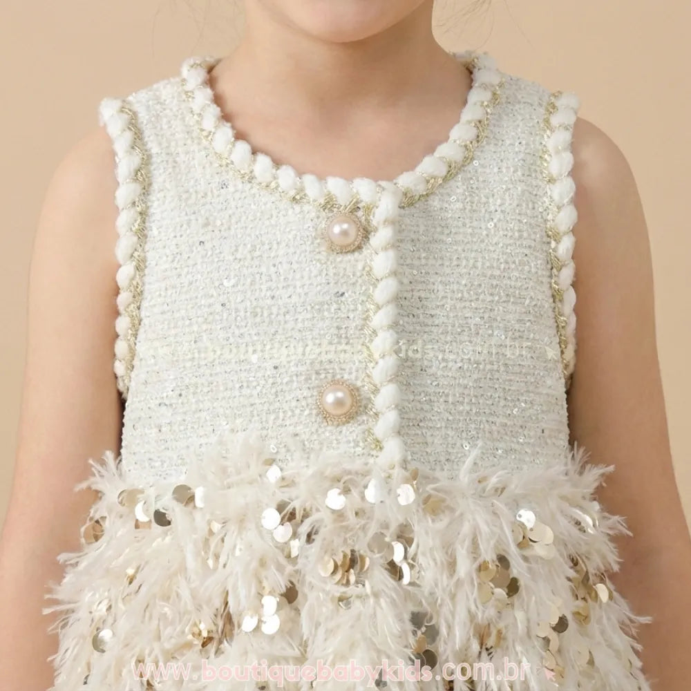 Close-up detalhado do busto do vestido infantil em tecido tweed, destacando os botões decorativos de pérola com dourado e o acabamento trançado na gola.