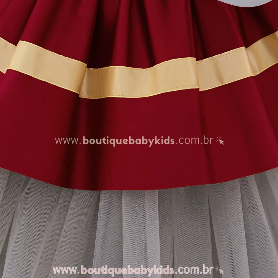 Saia rodada do vestido, com faixas douradas aplicadas na barra e sobreposição de tule cinza.