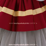 Saia rodada do vestido, com faixas douradas aplicadas na barra e sobreposição de tule cinza.